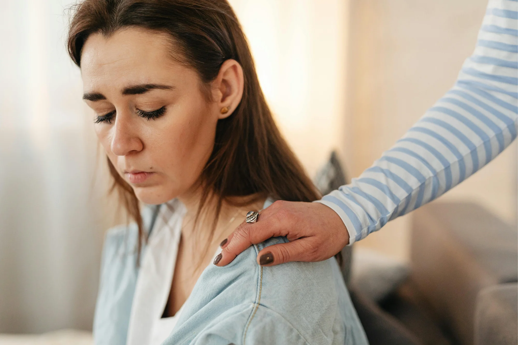 Woman with hand on shoulder