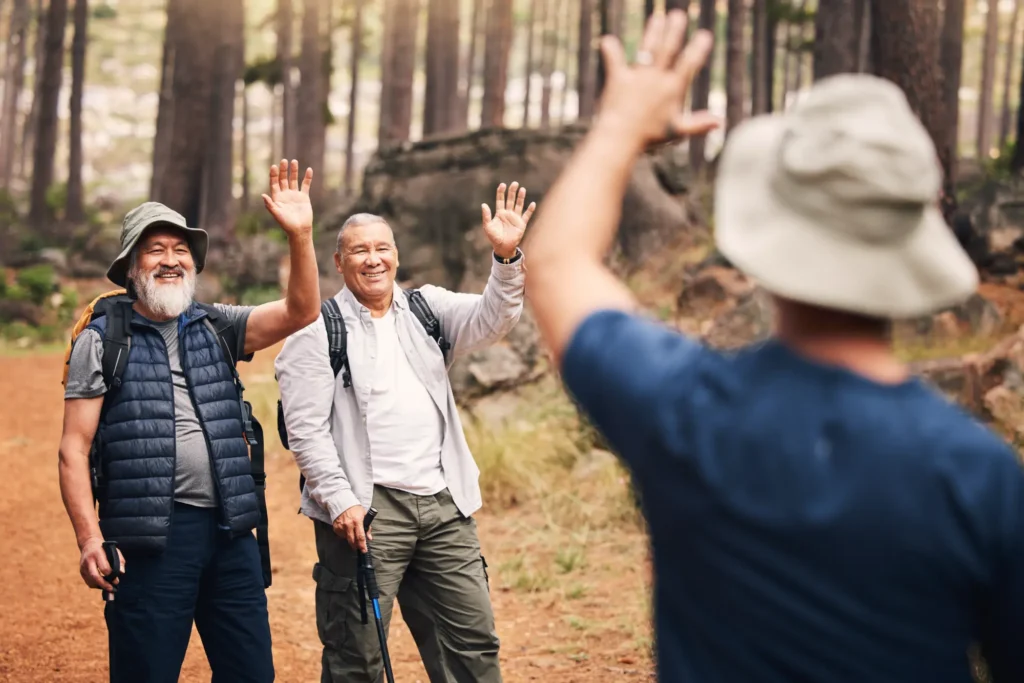 Group of men hiking near Denver, CO with one waiving after having total shoulder replacement