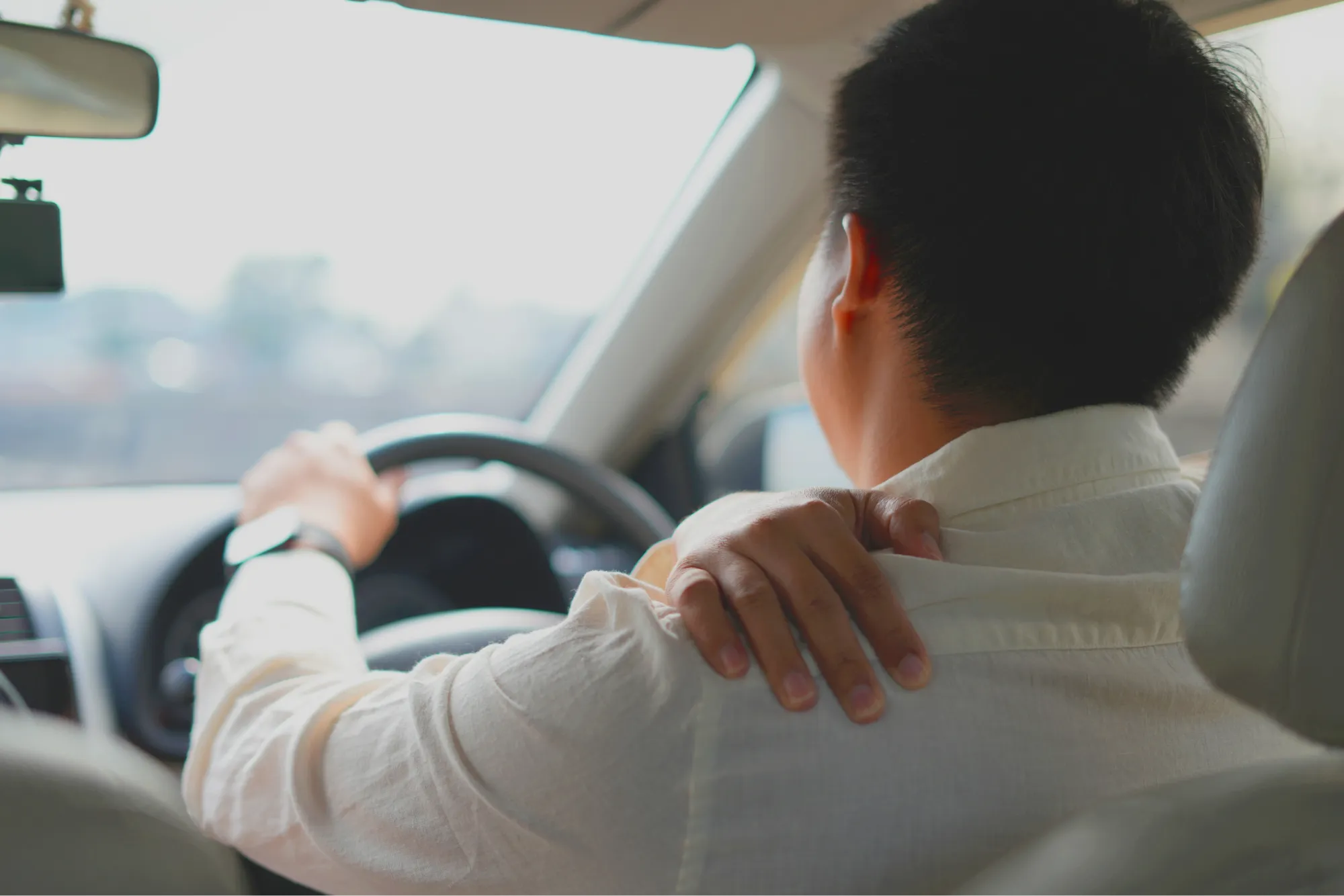 Patient driving their car after receiving reverse shoulder replacement treatment.