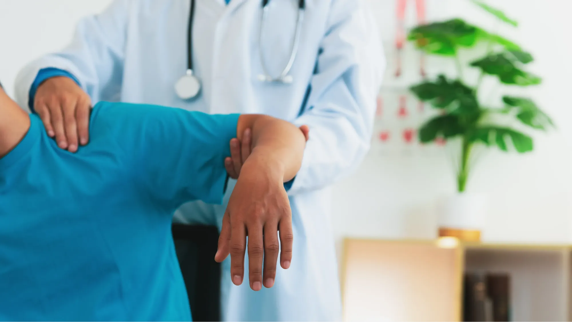 Doctor supporting a patient's arm while examining their shoulder range of motion